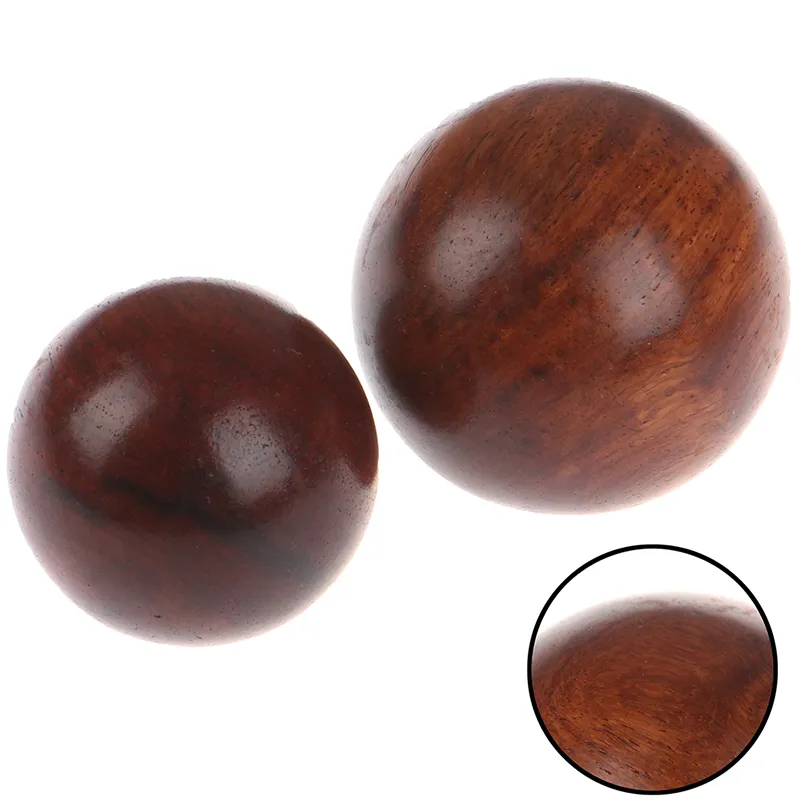 Size comparison showing 5cm diameter Baoding balls perfect fit for adult hands during exercise.