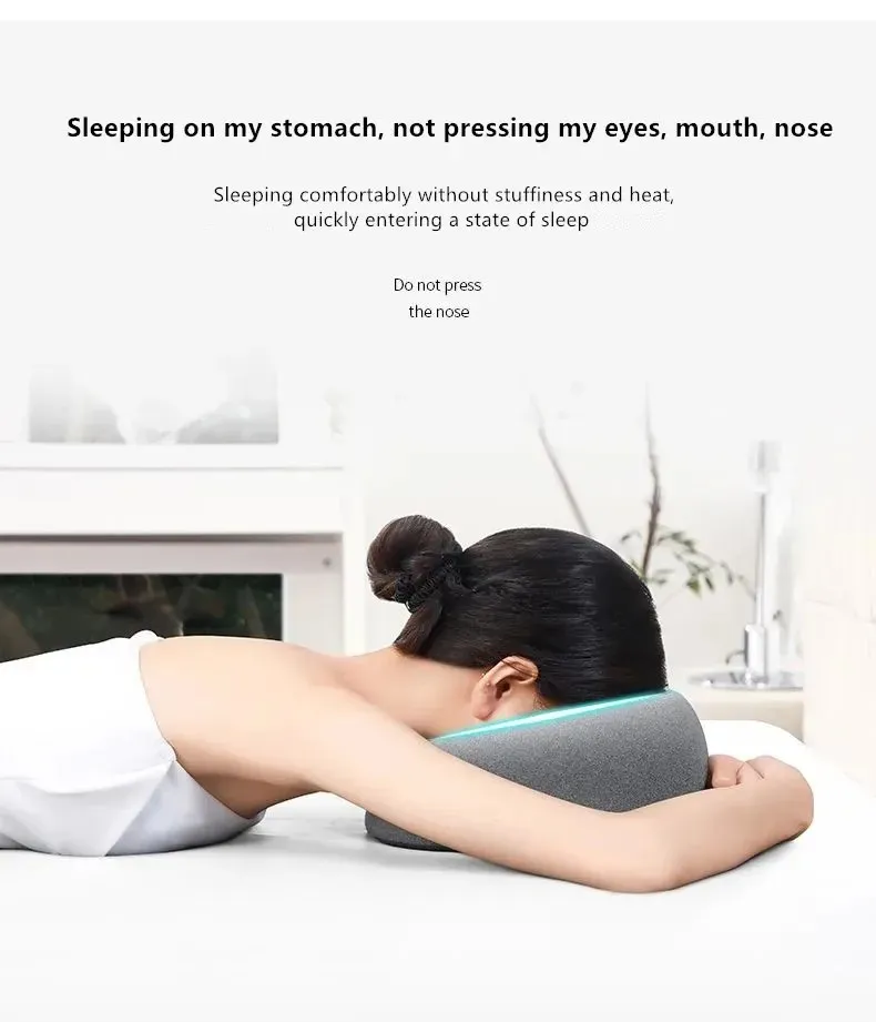 Person lying face down comfortably using ergonomic cervical pillow during massage therapy.