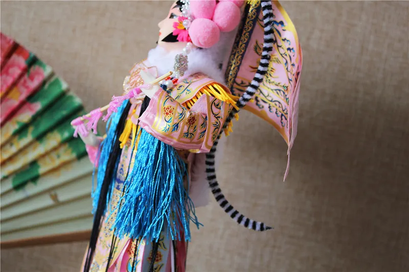 Close-up of intricate beading and silver thread details on opera doll headdress.