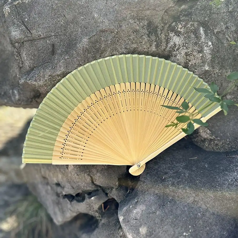Professional dancer performing with Japanese silk fan during traditional cultural routine.