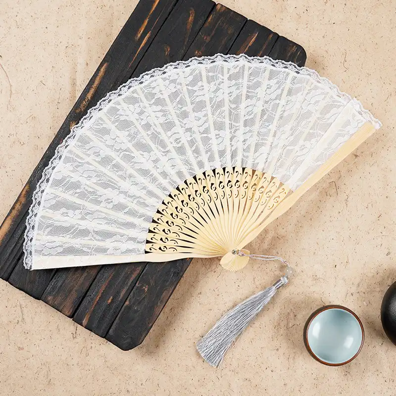 Hand held lace folding fan being used with hanfu traditional outfit in cultural styling.