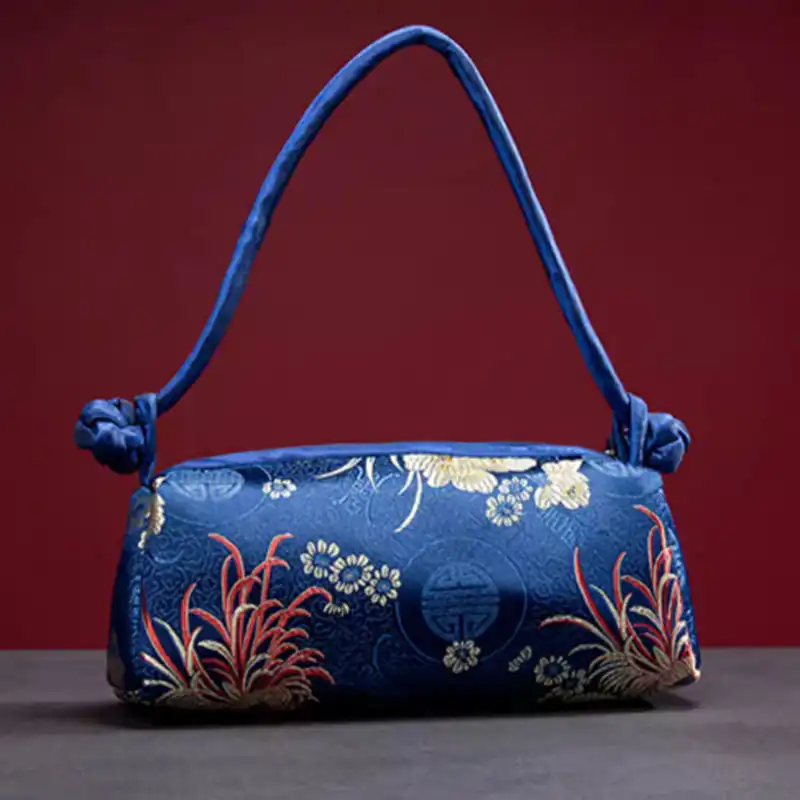 Fashion model carrying silk embroidered evening bag demonstrating sophisticated styling appeal.
