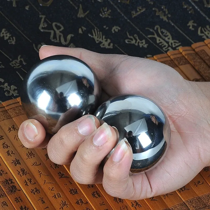 Person using Baoding balls for finger dexterity exercise and wrist strength training.