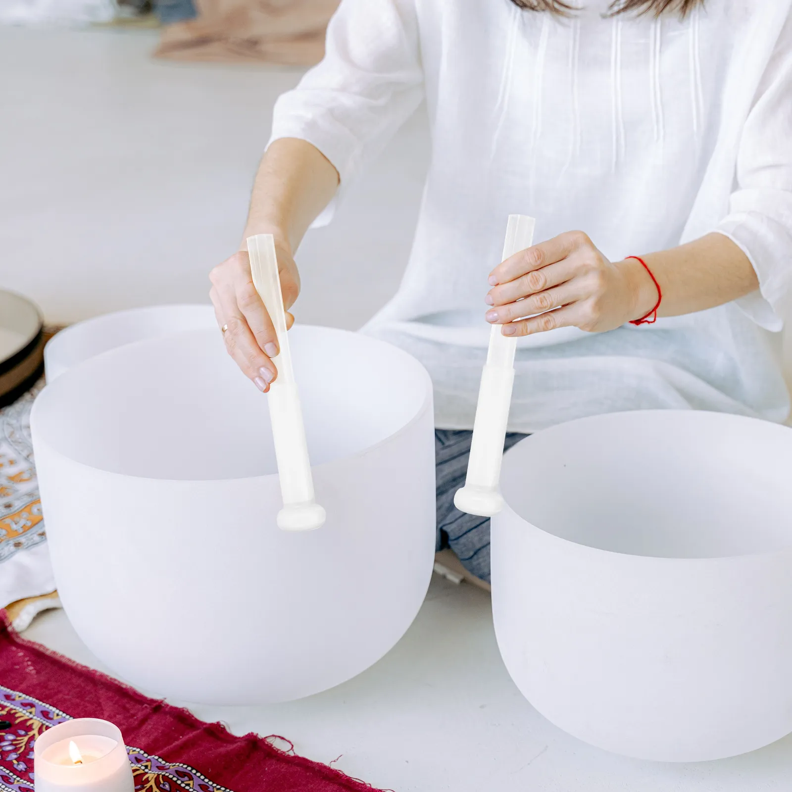 Acrylic mallet striking singing bowl producing clear sound vibrations for meditation therapy.