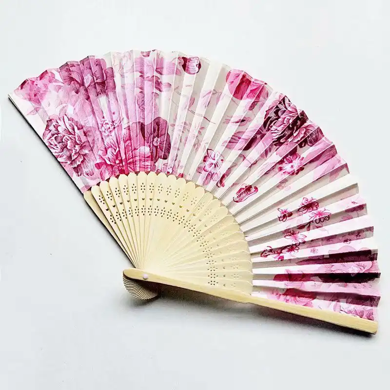 Japanese silk folding fan with printed flower patterns opened displaying bamboo ribs and tassel pendant.