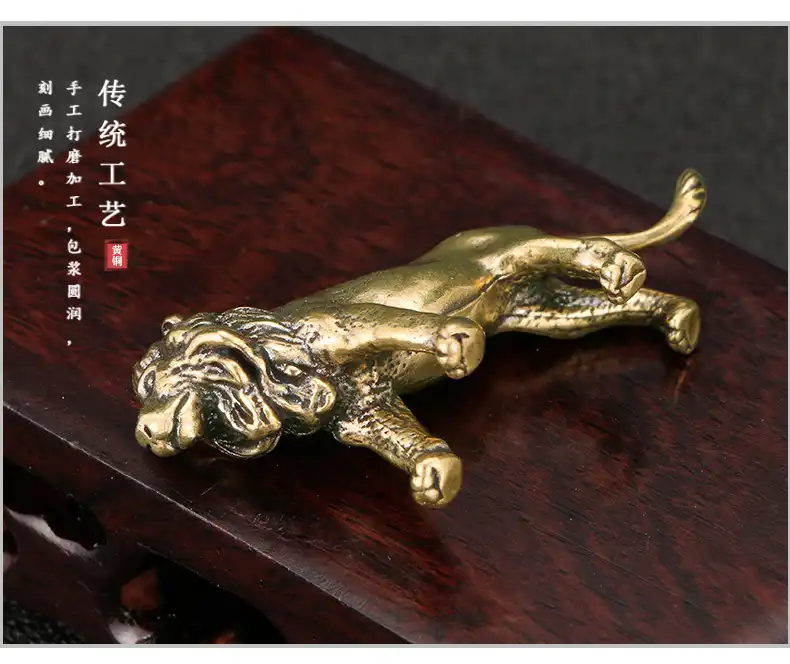 Hands holding the lightweight brass lion statue demonstrating its compact portable size.