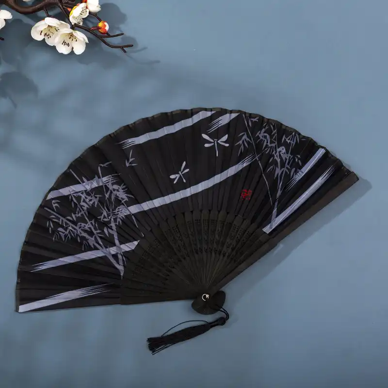 Wedding photography with bride holding Chinese folding fan as romantic accessory.