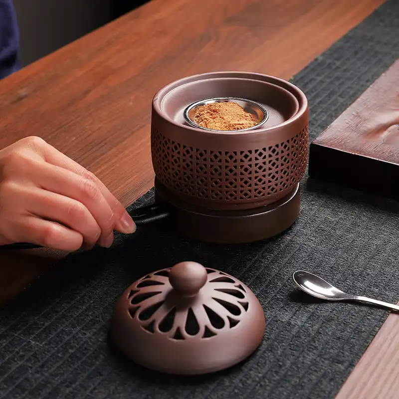 Compact electric aromatherapy furnace heating essential oils with visible steam rising gently.