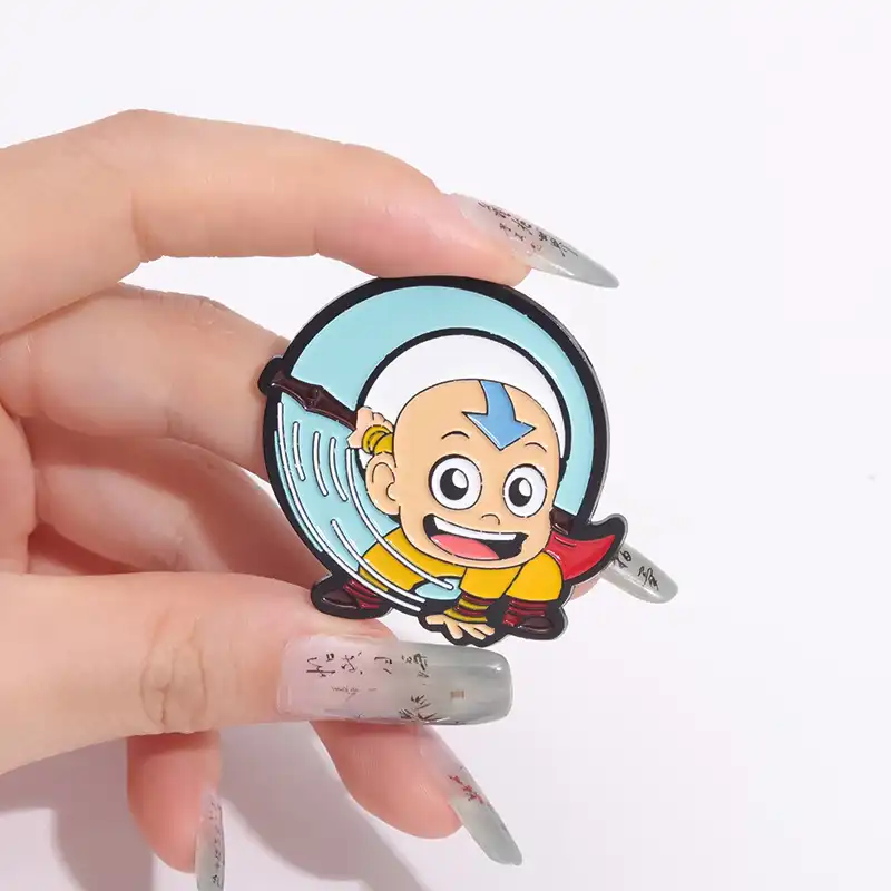 Little monk enamel pin with secure clasp, displayed on stand..