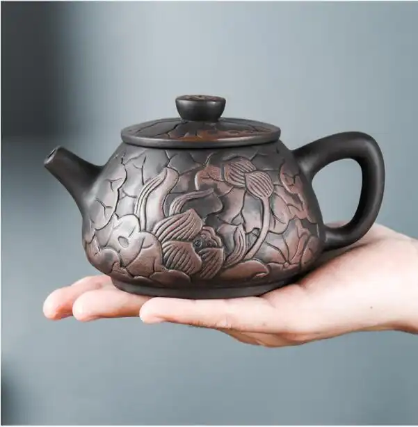 Handmade beauty kettle lid and knob showing complementary lotus design elements and smooth texture.