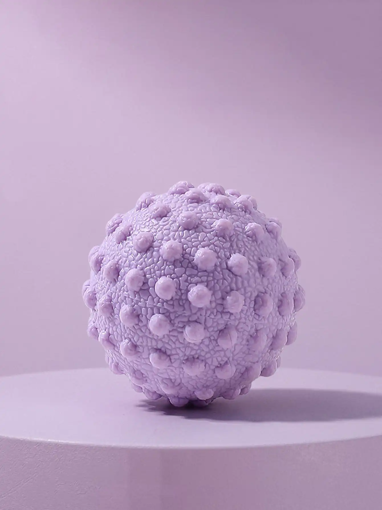 Portable fascia massage ball for posture, used on table..