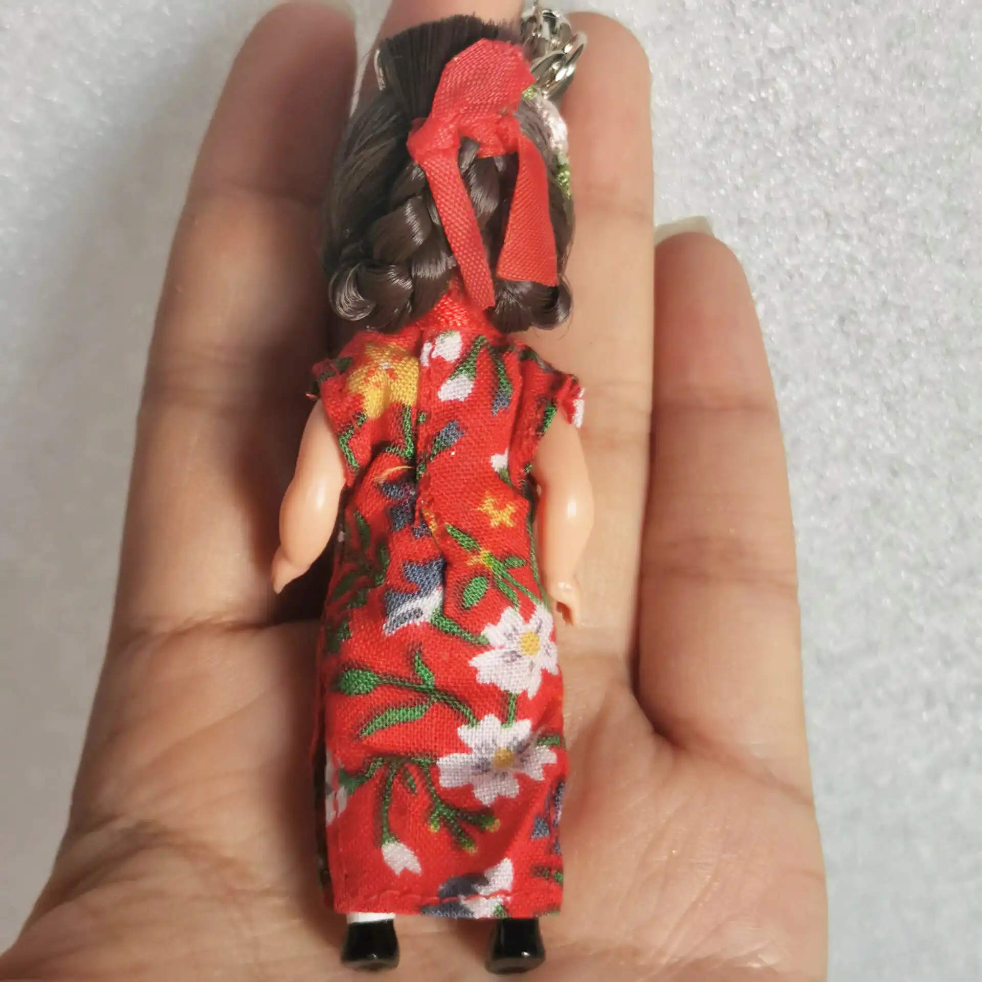 Mini princess doll keychain displayed with keys showing practical accessory functionality.