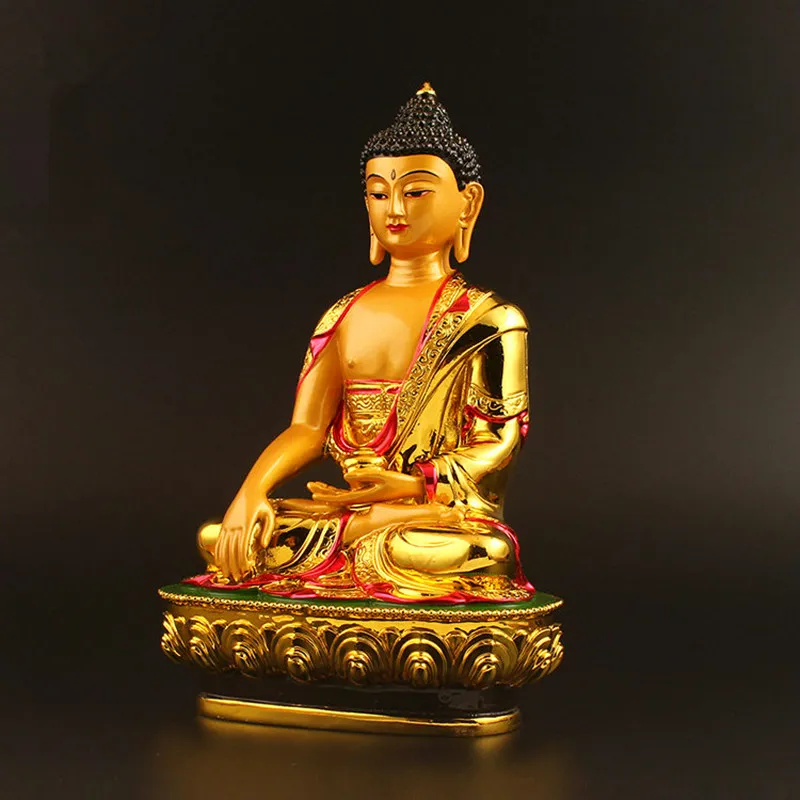 Tibetan Buddha statue on meditation altar with candles and spiritual items for zen practice.