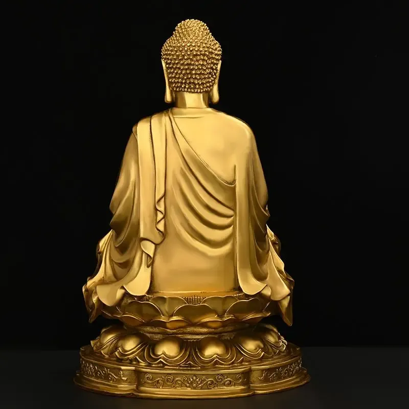 Office desk decoration featuring copper Buddha statue among professional workspace items.