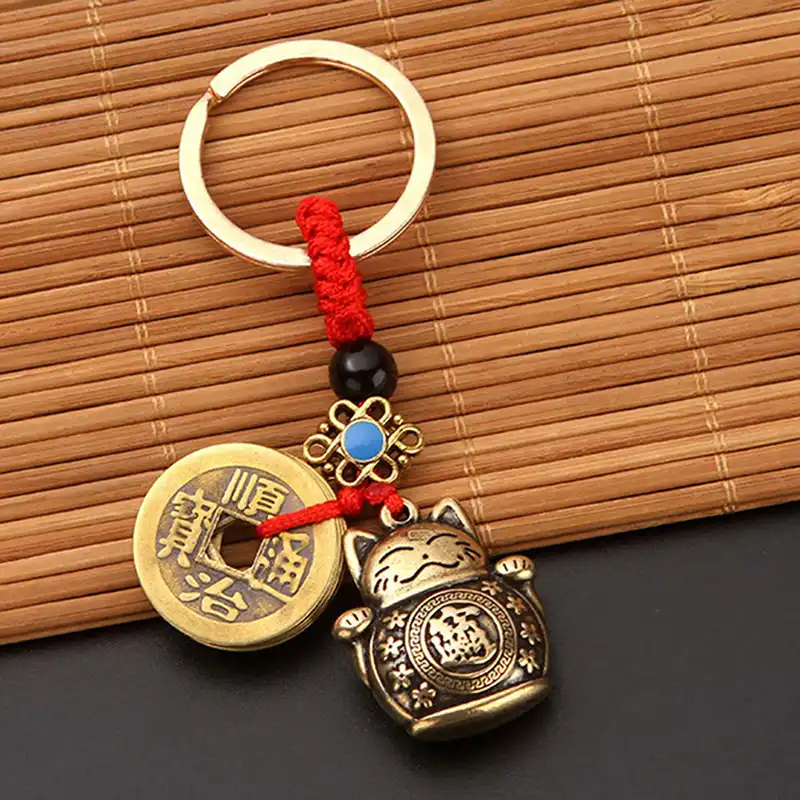 Side angle view showing dimensional details of brass lucky cat and coin charms.
