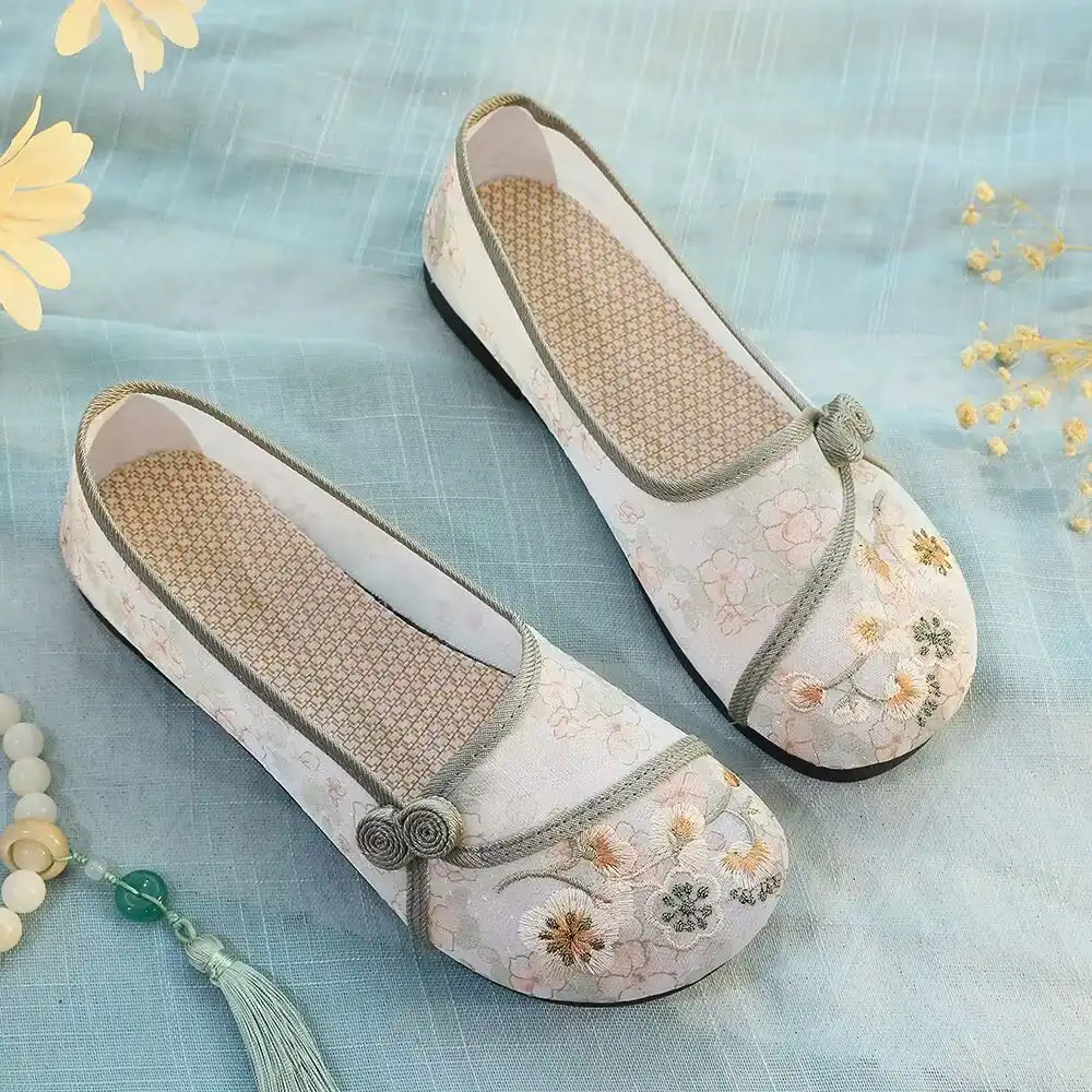 Multiple color options of embroidered Old Beijing cloth shoes displayed in attractive arrangement.