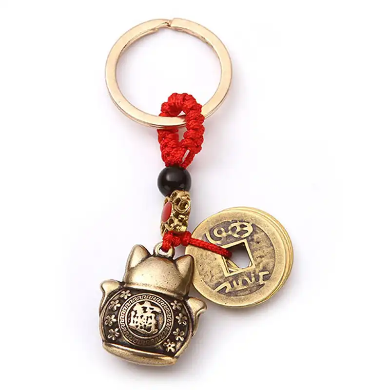 Lucky cat keychain clipped to handbag showing versatile accessory usage.