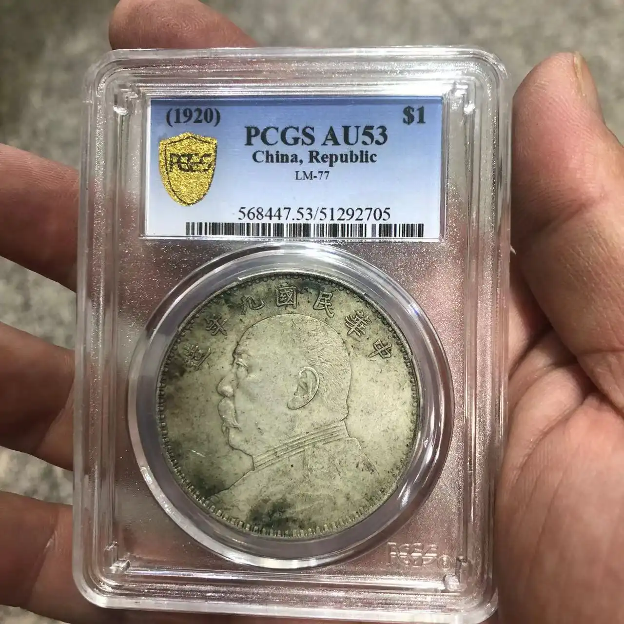 Protective coin holder displaying both sides of authenticated Chinese silver dollar.
