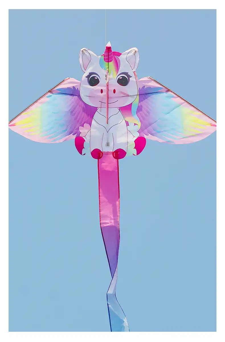 Pink unicorn kite flying gracefully in blue sky showing magical design and flowing mane details.