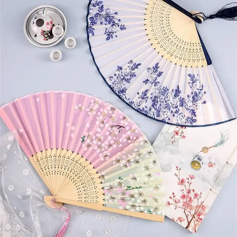 Vintage Japanese silk folding fan opened displaying traditional bamboo ribs and elegant oriental pattern.