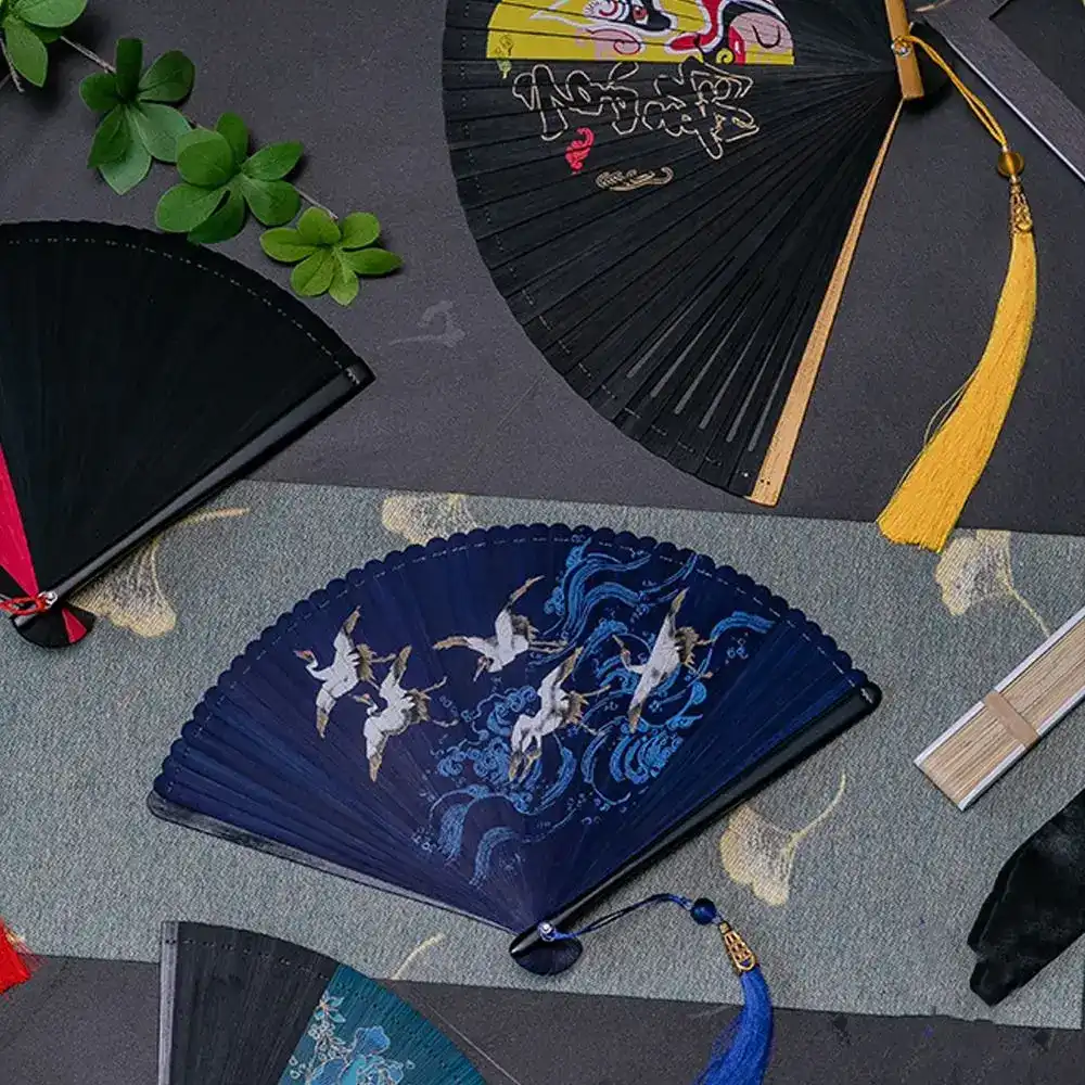 Japanese black bamboo folding fan displayed fully open showing classical ancient style design.