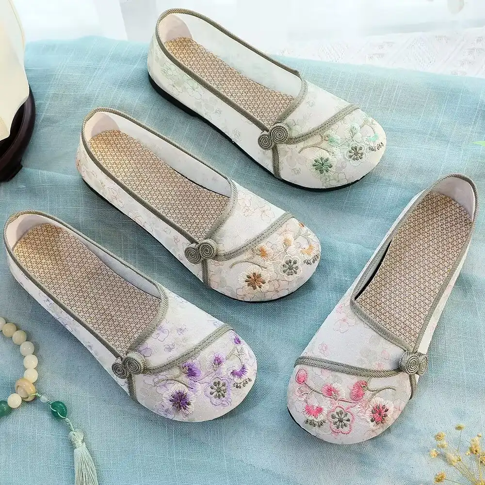 Traditional Chinese cultural background setting with embroidered Old Beijing cloth shoes display.