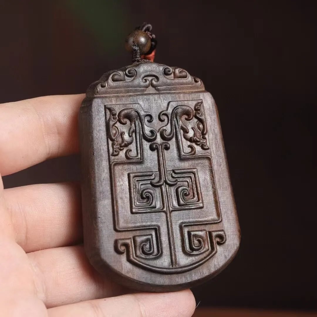 Agarwood car pendant displayed as perfect gift with traditional Chinese crafts presentation.