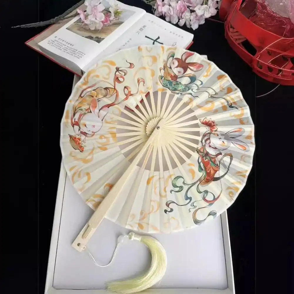 Decorative tassel detail on round bamboo fan showing traditional styling elements.