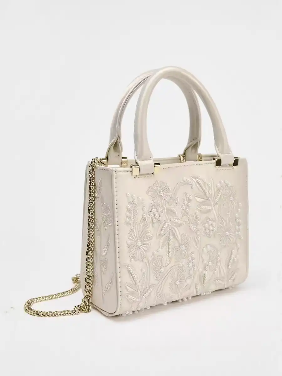 Stylish woman carrying floral embroidered silk shoulder bag demonstrating versatile daily use.