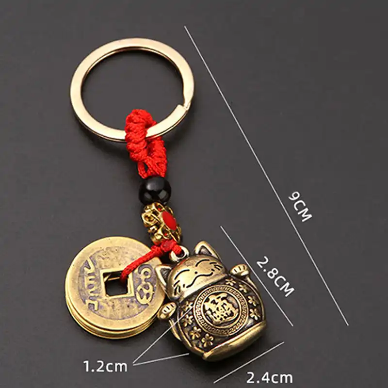 Comparative size view of feng shui keychain next to common household items.