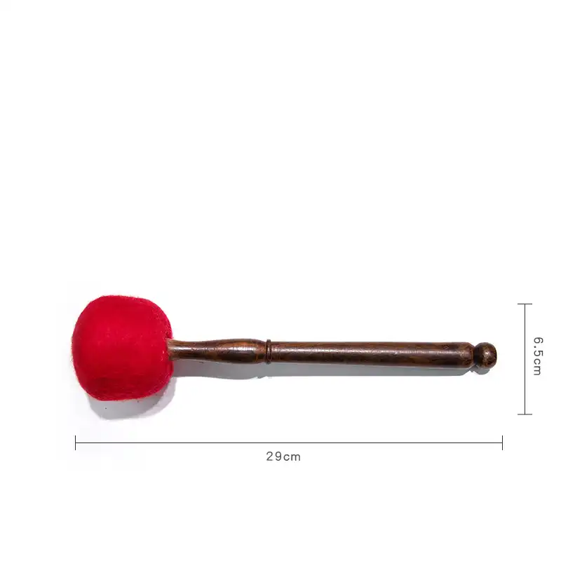 Buddhist meditation setup with leather mallet and singing bowl on altar cloth.