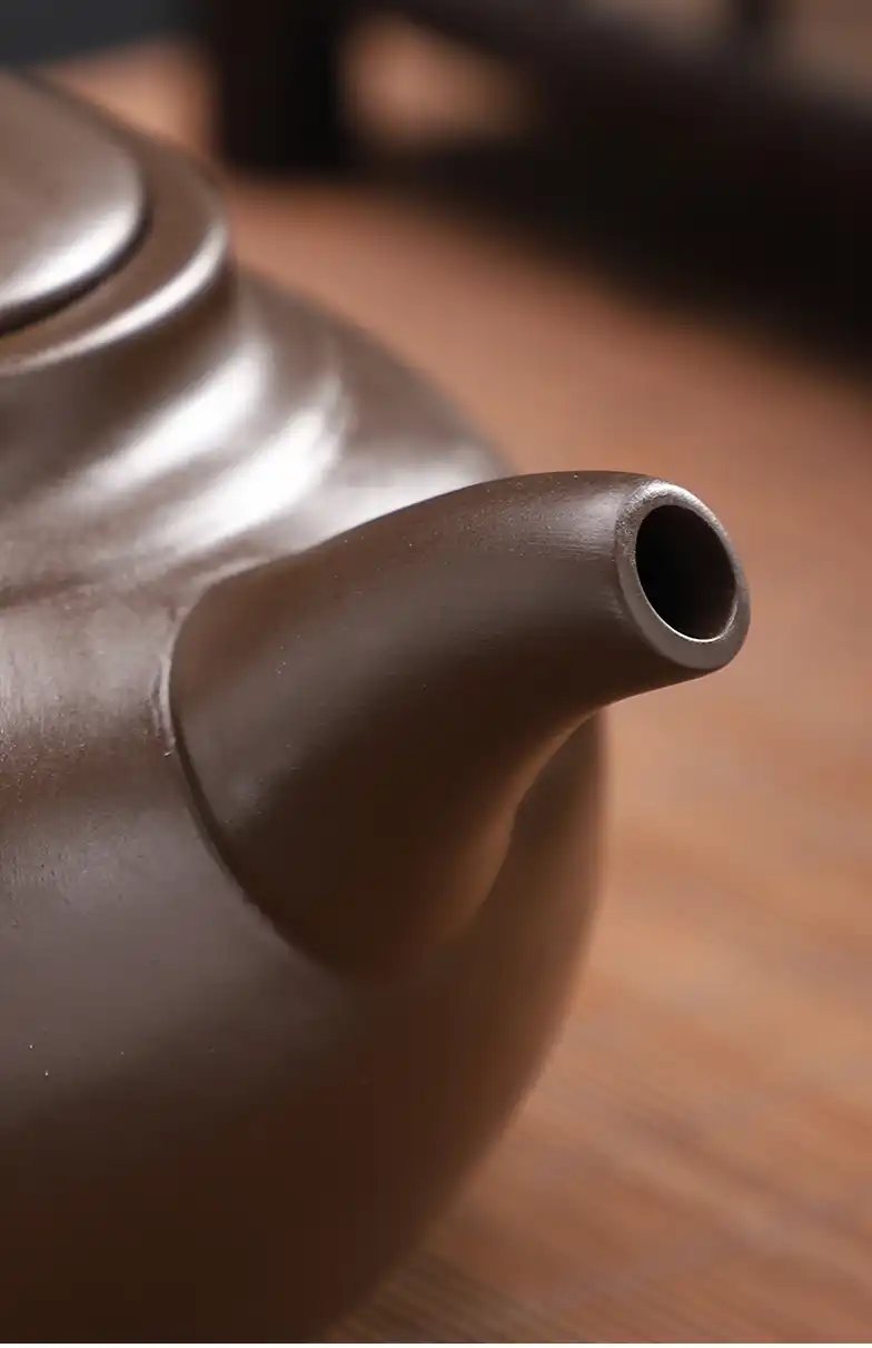 Tea brewing process using Yixing beauty teapot showing proper pouring technique and golden tea color.