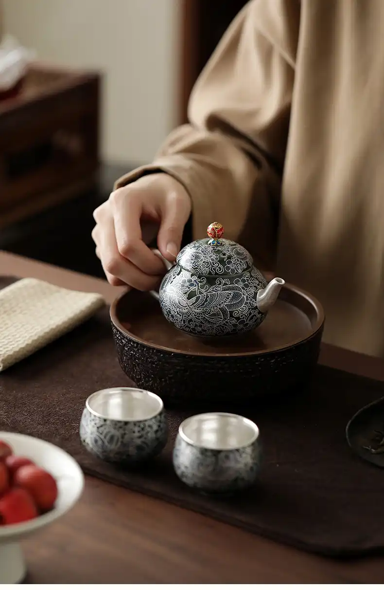 Hand-painted butterfly and floral details on premium ceramic teapot and matching cup collection.