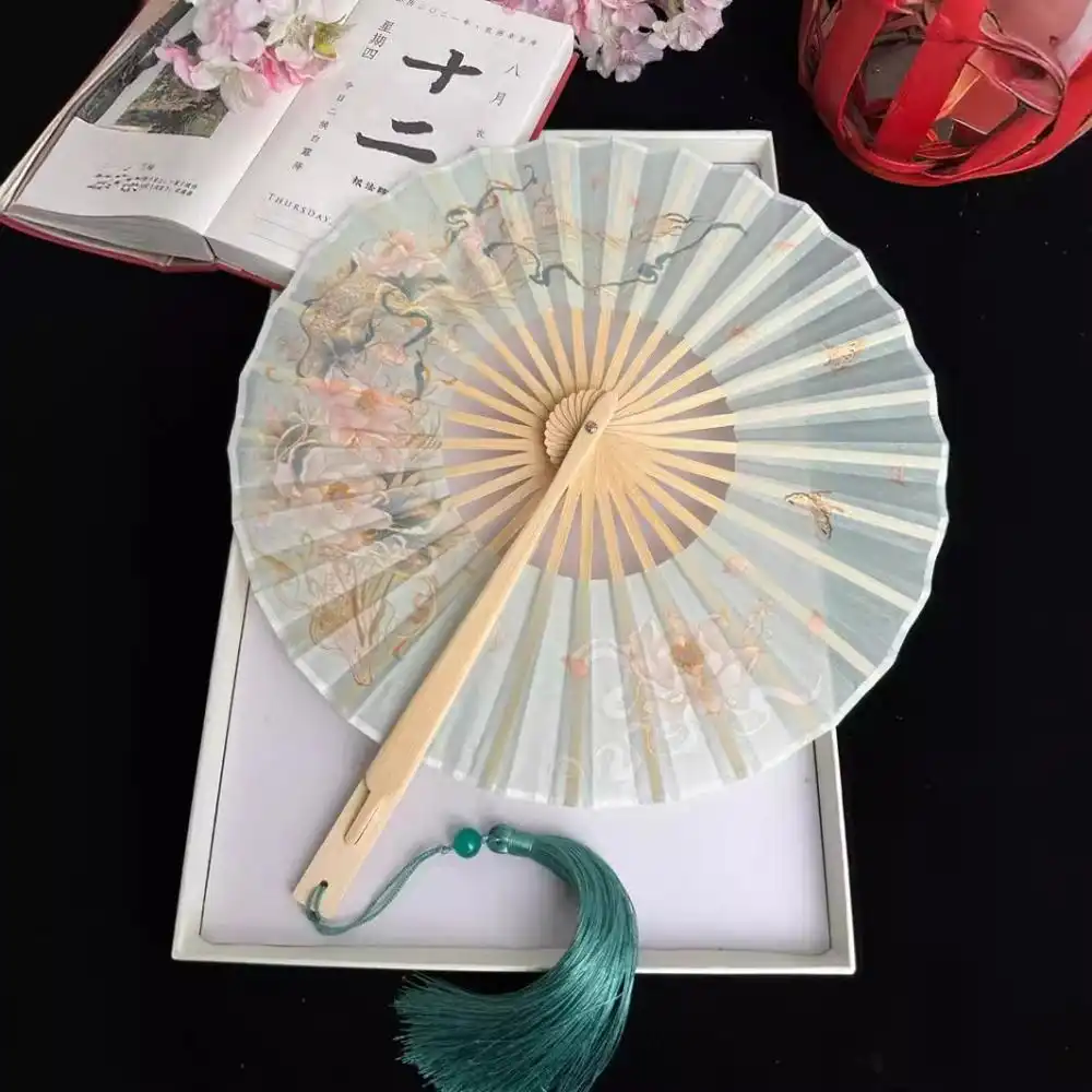 Collapsible round fan folded flat demonstrating compact portable storage design.