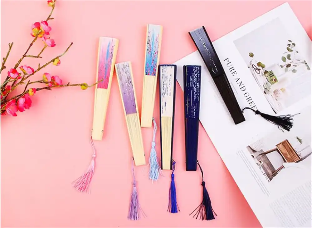 Gift presentation of black bamboo silk folding fan in elegant packaging display.