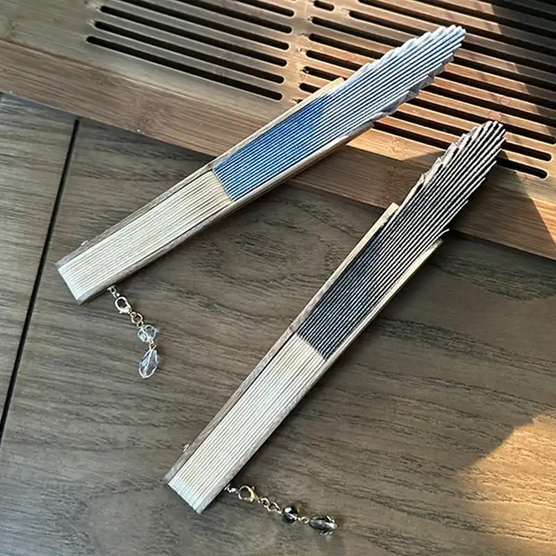 Pendant accessory attached to Japanese folding fan showing decorative detail and traditional styling.