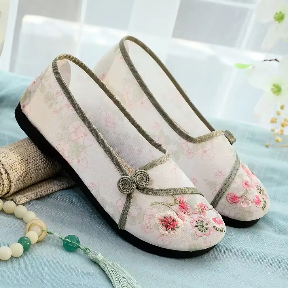 Elegant packaging presentation of embroidered Old Beijing cloth shoes for gift giving.