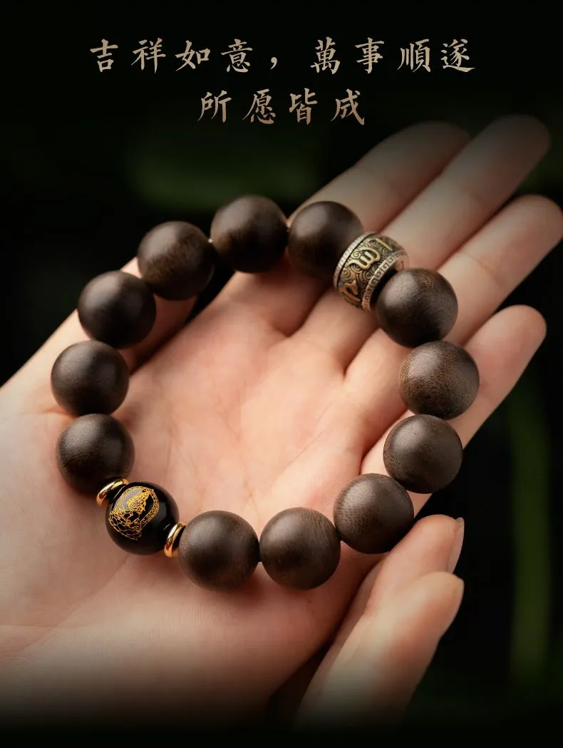Detailed view of zodiac Buddha plate charm attached to natural agarwood beaded bracelet.