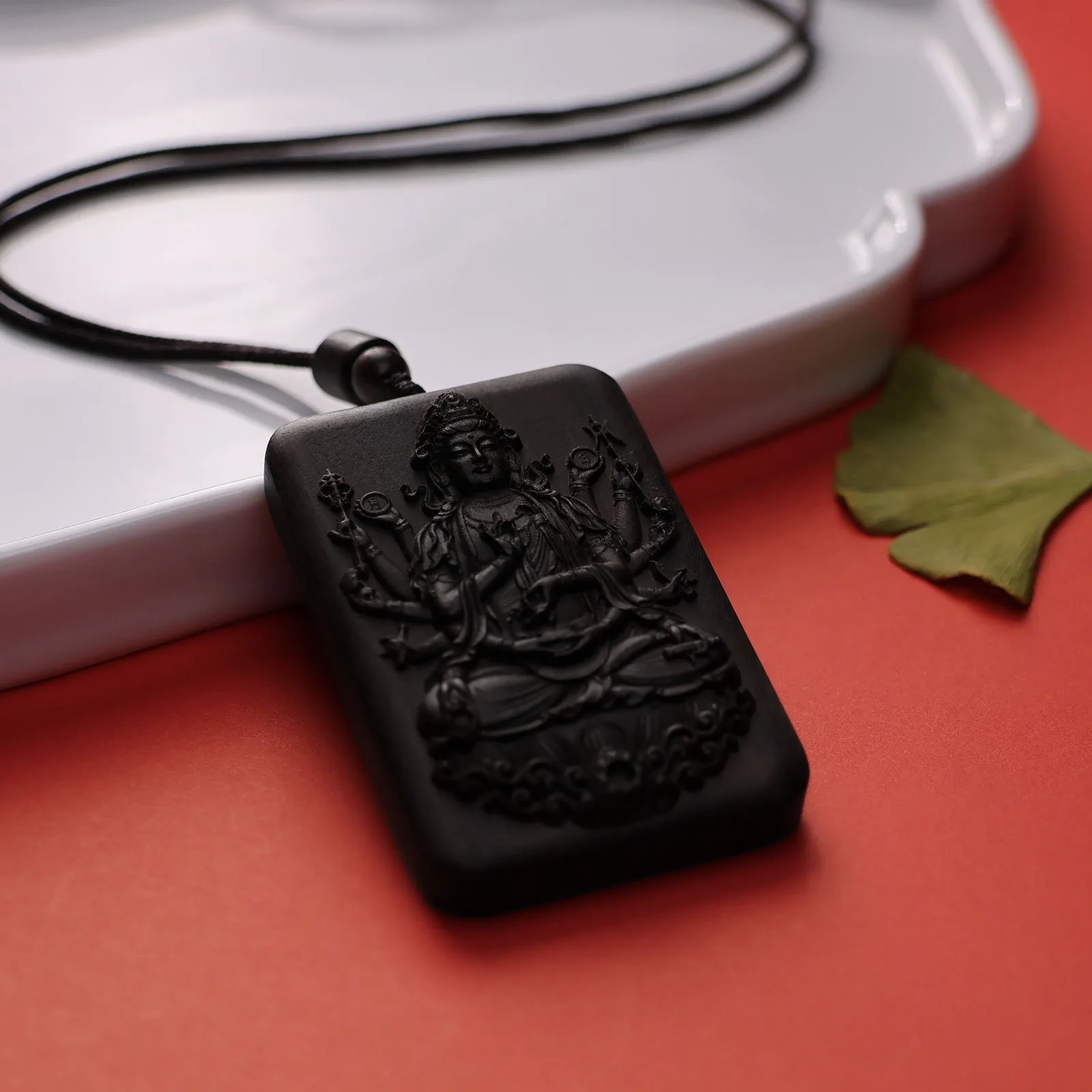 Agarwood Thousand Hand Guanyin necklace in peaceful meditation setting with Buddhist decor.