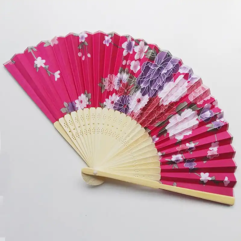 Closed silk folding fan with tassel showing compact size and traditional Japanese design elements.