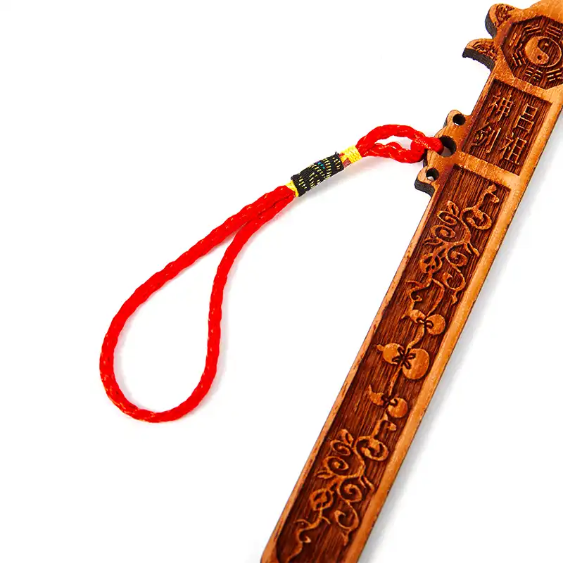 Tai Chi Eight Diagrams Peach Wood Sword hanging on wall for feng shui home protection and decor.