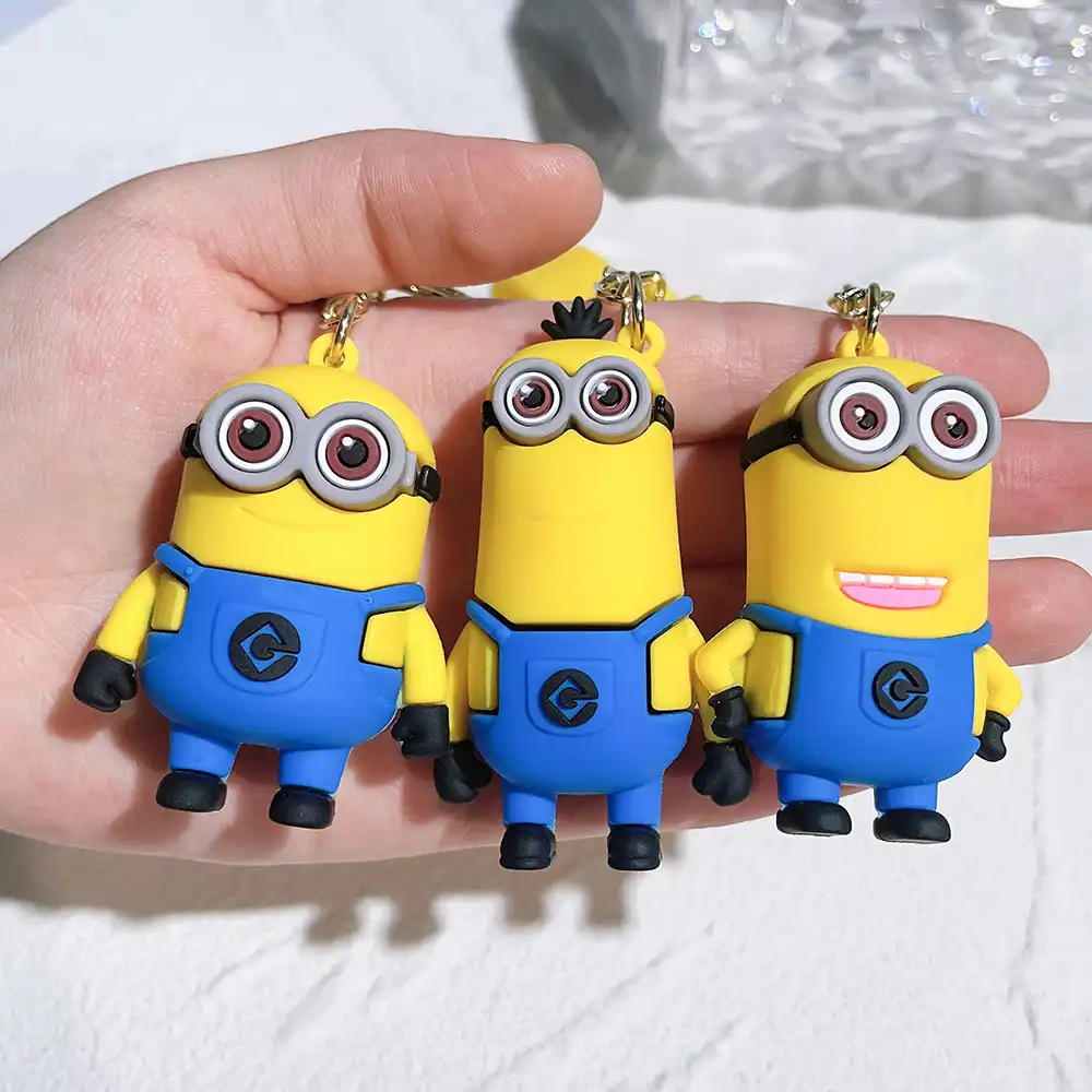 Comparison size reference of Minions keychain next to coins showing compact portable dimensions.