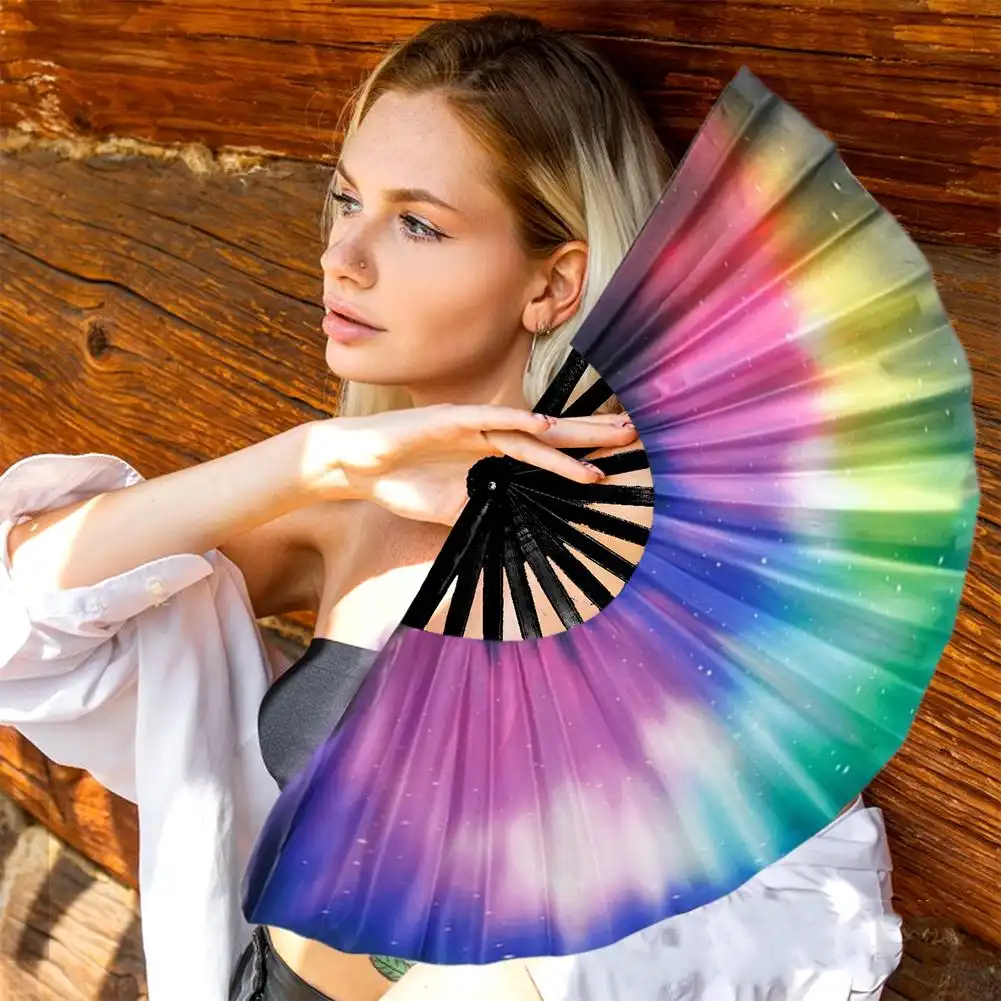 Group photo of people holding various glowing UV fans at outdoor night festival celebration event.
